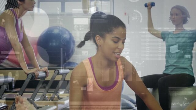Pilates trainer placing hands on client, guiding core hold to align while HUD showing reformer work