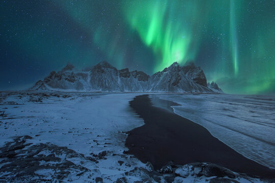 aurora over above Vestrahorn and its black sand beach in Iceland