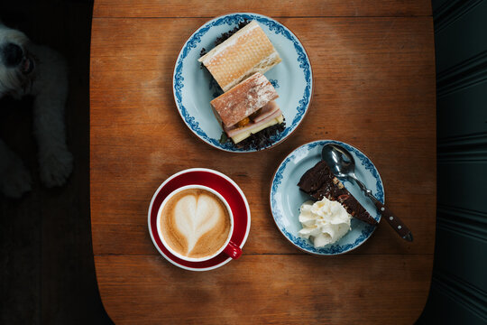 cafe latte with chocolate cake and sandwiches on a table in a cafe