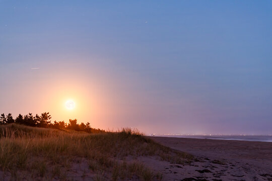 Supermoon rise over beach dunes in October 2024