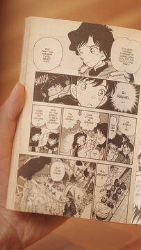 Over shoulder reading Case Closed - Detective Conan manga comic in black and white illustrations