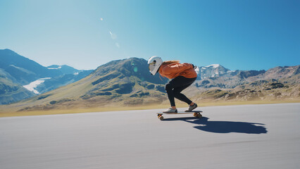 woman skateboarding and making tricks between the curves on a mountain pass. © oneinchpunch