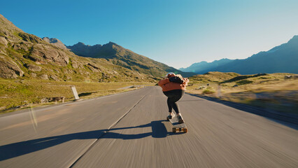 Obraz premium woman skateboarding and making tricks between the curves on a mountain pass.