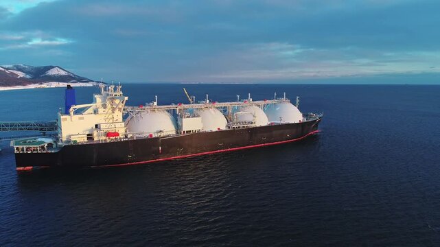 Aerial of Liquified Natural Gas LNG carrier moored to a small gas terminal. Fuel crisis. Sanctions