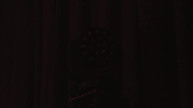 Bright flare explodes against dark curtain, whiteyellow bloom reveals par fixture silhouette on truss, stage crew cueing strobe and lighting pulse creates nightclub vibe and highcontrast moment