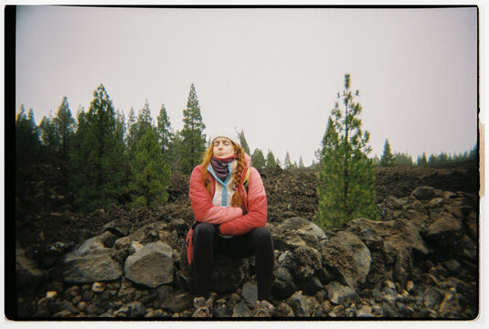 Hiker resting on rock in cold volcanic landscape