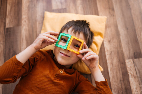 Child playing with square toys on floor indoors