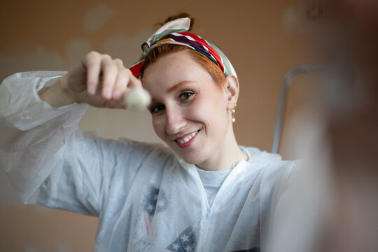 Smiling woman taking a selfie while painting at home