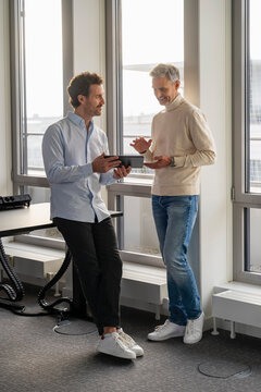 Two men having a business meeting with a tablet in an office