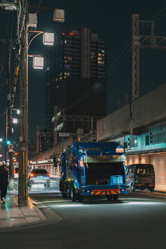 Garbage truck driving on night street in urban Osaka Japan