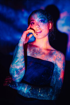 Studio portrait of teenage girl with colorful galaxy led projector illumination