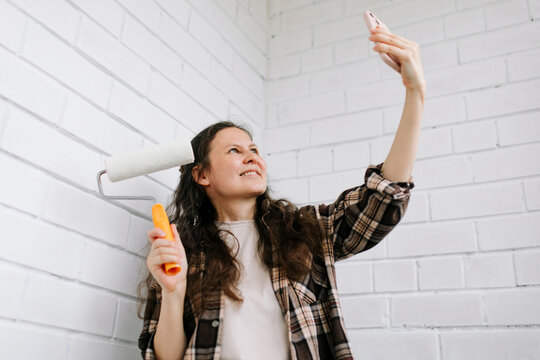 Woman taking a selfie with smartphone during home renovation