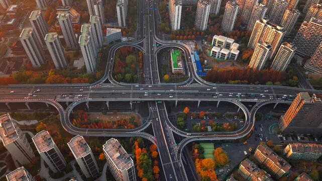 Aerial shot of complex freeway interchange with flowing traffic in Hangzhou, China during sunset.
