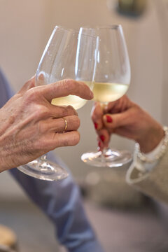 Toasting with white wine in glass at home