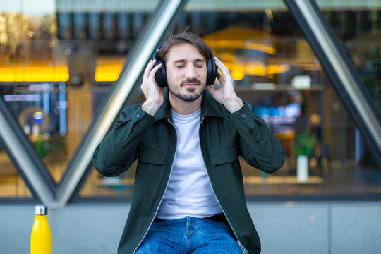 Commuter relaxing outdoors in the city listening to music