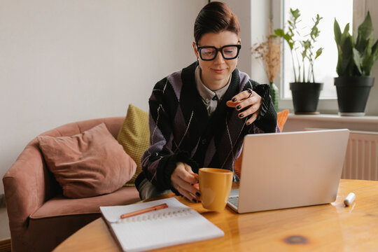 Professional creative manager working from home on laptop with coffee