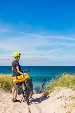 Woman with e-bike on Baltic Sea cycle path near Wustrow beach dune