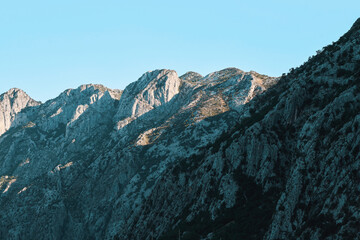 Fototapeta premium Majestic rocky mountain peaks rising dramatically towards a clear blue sky