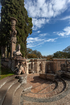 Stone sculptures of a satyr and horse overlooking a curved staircase in the gardens of Villa Farnese, Caprarola, Italy. High Renaissance garden architecture.