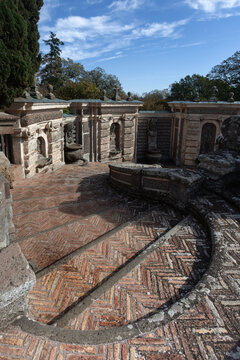 Historic brick stairs with herringbone pattern in the upper gardens of Villa Farnese, Caprarola, Italy. Background shows ornate stone walls and niches.