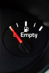 Naklejka premium Car fuel gauge showing empty tank. Red needle pointing to low gasoline level in dashboard. Concept of rising oil price and expensive transportation cost, energy crisis and inflation.