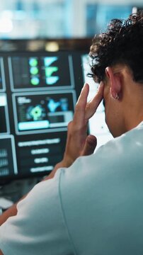 Man, programmer and headache with computer for eye strain, fatigue or overworked in office. Back view, male person or software developer with migraine, sore ache or stress for burnout in workplace