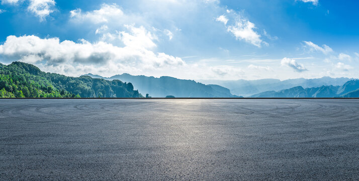 Empty asphalt road and scenic mountain landscape under a blue sky with white clouds, Hunan, China