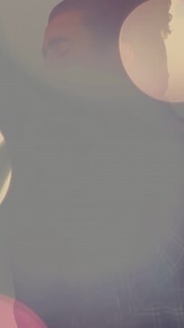 Vertical video: Male singer bringing retro mic close causing bright bokeh flare singing music promo