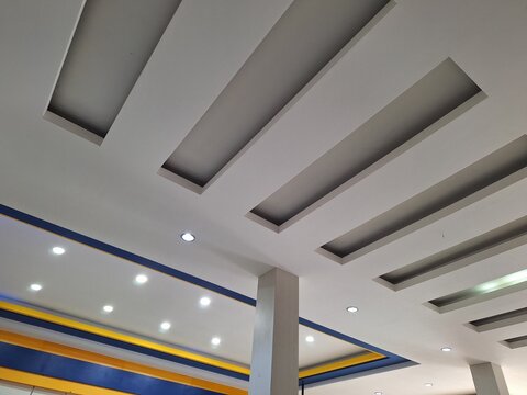 Modern recessed ceiling with recessed lighting and blue yellow accents