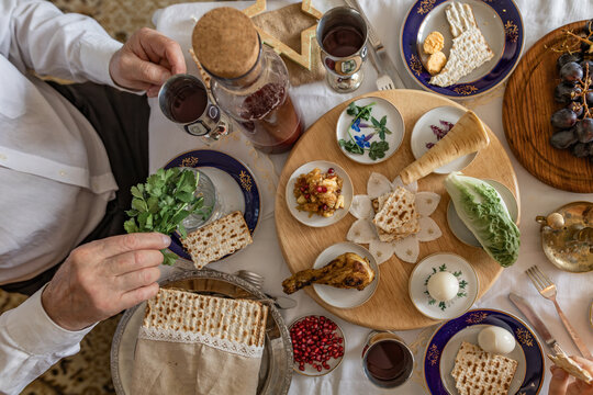 Grandparent holding parsley at a family Passover seder table indoors