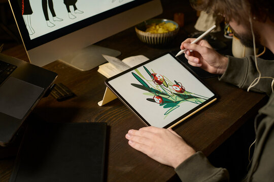 Freelance graphic designer drawing on a graphics tablet at home
