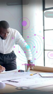 Vertical video: Male designer checking plans while peer marking, HUD tagging points for plan review