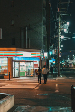 Couple walking past a convenience store in Osaka at night