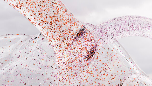 Abstract macro shot of transparent fluid with colorful glitter
