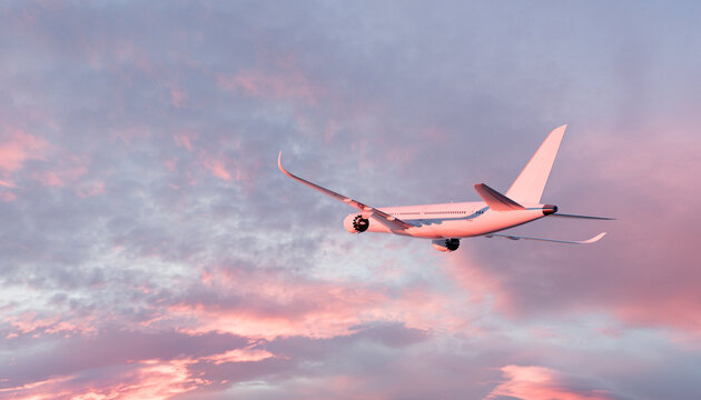 White airplane flying through cloudy sky at sunset