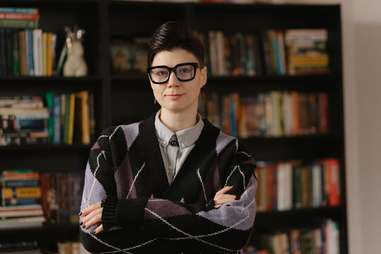 Confident creative director with crossed arms in library
