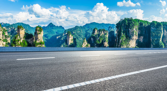 Empty asphalt road leading towards majestic sandstone pillars in Zhangjiajie National Forest Park, China