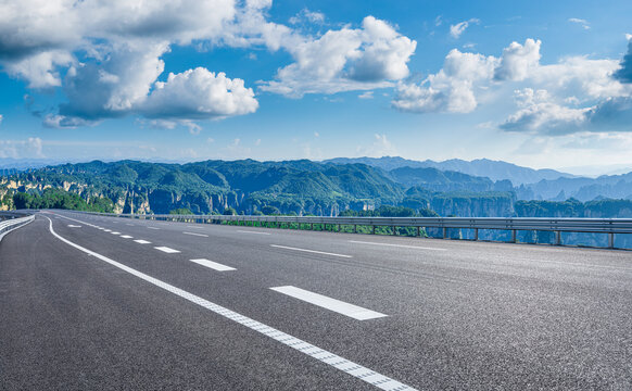 Empty asphalt road leading towards sandstone pillars in Zhangjiajie National Forest Park, China