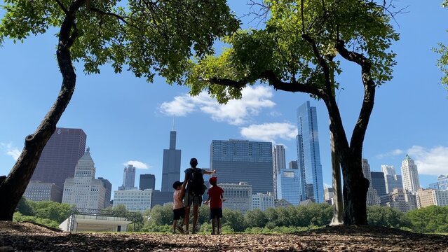 Family enjoying urban park view of chicago skyline with willis tower, embracing travel, tourism, and summer vacation exploring city destinations
