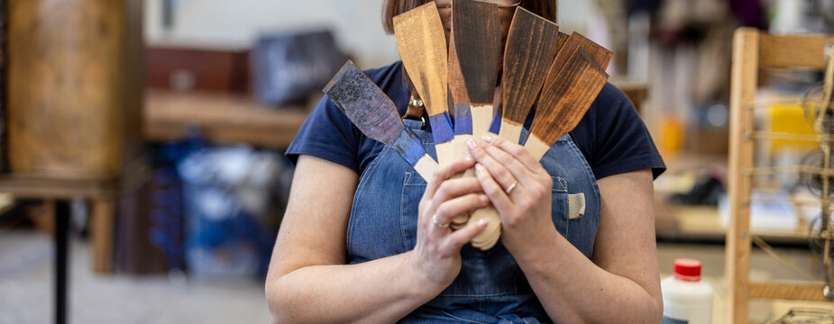 Woman Holding Wood Stain Color Samples in Carpentry Workshop
