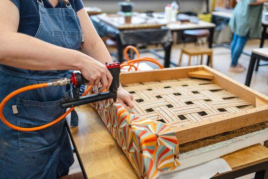 Attaching the upholstery fabric to the wooden chair frame
