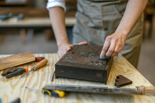 Restoring Decorated Wooden Box with Hand Tools on Workbench
