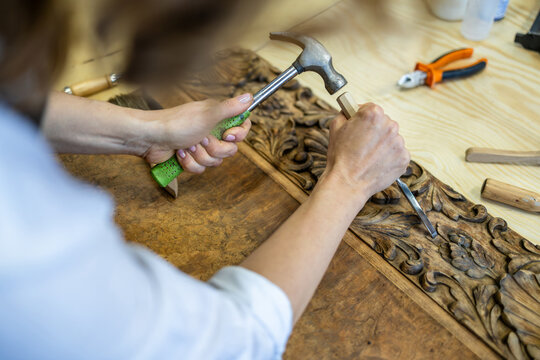 Restoring Ornate Wooden Panel with Carving Tools

