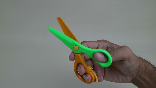 Hand Demonstrating Opening and Closing Colorful Plastic Scissors