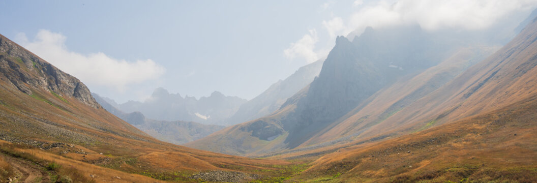Expansive yellow valleys dotted with rocky formations, showcasing striking natural landscapes, rugged terrain, and the warm, earthy tones of a scenic wilderness.