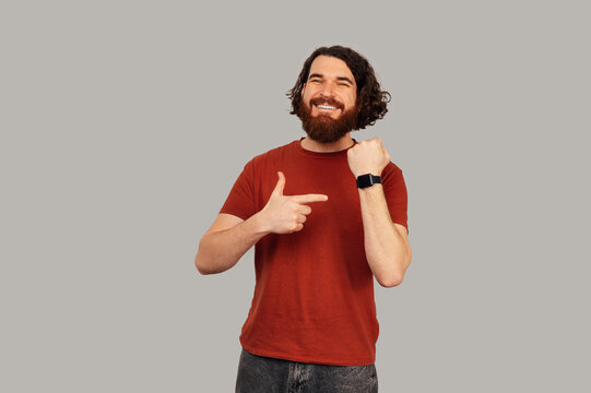 Caucasian Man Pointing At Wristwatch Display, Bearded User In Red Tee Showcasing Wearable Tech And Time