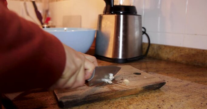 Person chopping fresh scallions in kitchen