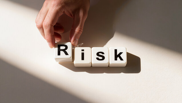 Hand Arranging "Risk" Blocks on Table - Business Management Concept