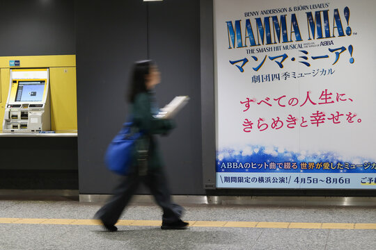 TOKYO, JAPAN - April 22, 2026: Detail of a subway station with a poster for the musical Mamma Mia! Some motion blur.