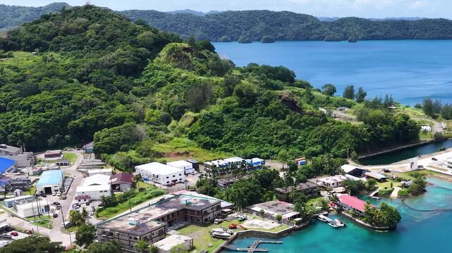 Aerial view of Malakal harbor and coastal development in Koror Palau with lush tropical green hills and blue water.